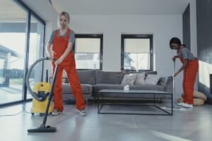 women in orange uniform cleaning the floor