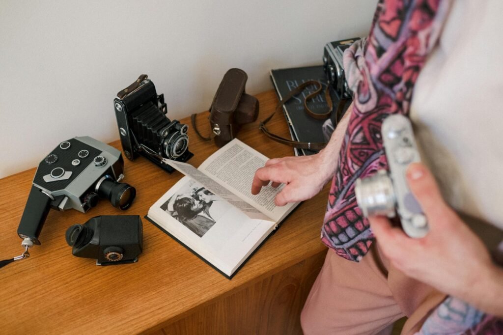 unrecognizable male person holding photo camera and reading book