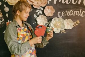 woman in apron labeling handmade cup