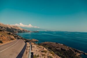 empty road near calm body of water