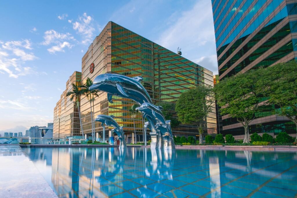 three blue dolphins statue front of water near building