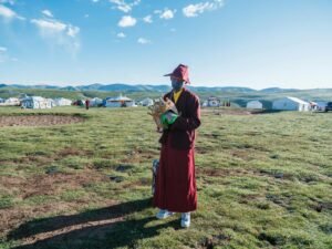 a person in traditional clothing standing on a grass field