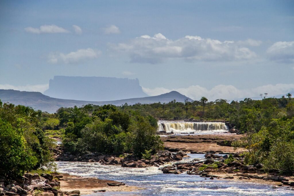 scenic panorama with river cascade and a distant tepui mountain canaima national park venezuela