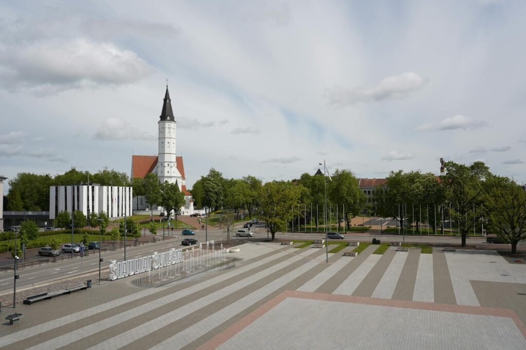 A view of Šiauliai, Lithuania featuring a prominent church and city square.