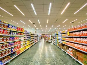 A grocery store aisle with shelves stocked with cereal boxes and milk cartons