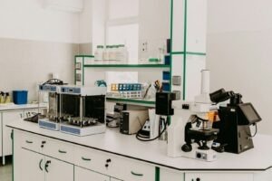 A laboratory workbench with a microscope and analytical equipment in a bright room
